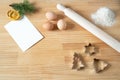 Homemade Christmas cookies. Blank greeting card or business card on wooden work table. Rolling pin, cookie cutters, eggs. Template Royalty Free Stock Photo