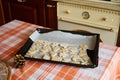 Carved gingerbread cookies in the shape of a heart, candle, candy cane, bird, angel wings, snowflake on the baking sheet