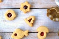 Homemade christmas cookies with red jam on white wooden background