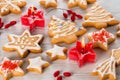 Homemade Christmas cookies shaped like stars, firs and snowflakes with white icing and red candles on wooden table background, Royalty Free Stock Photo