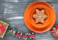 Homemade christmas gingerbread cookies and empty orange plates on gray wooden background. Snowflake, star, tree, snowman, Royalty Free Stock Photo