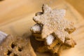 Homemade Christmas gingerbread cookies powdered, in shape of star, on a wood board, close up
