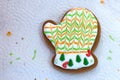 Homemade Christmas gingerbread decorated in the form of mittens on the background of a white napkin with the remains of glaze.