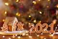 Homemade Christmas gingerbread house decorated with cookies on the table with numbers of new year and lights Royalty Free Stock Photo