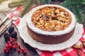 Homemade Christmas or New Year holiday berry pie with nuts on wooden table background. Concept of festive desserts