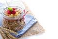 Homemade citrus granola in a glass jar on white