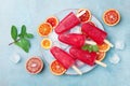 Homemade citrus ice cream or popsicles decorated mint leaves and orange slices on blue table top view. Frozen fruit juice. Royalty Free Stock Photo