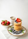 Homemade classic pancakes with fresh blueberries, strawberries powdered sugar and glass of milk. Summer breakfast Royalty Free Stock Photo