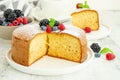 Homemade classic vanilla sponge cake or biscuit sprinkled with powdered sugar and fresh berries