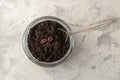 Homemade coffee face and body scrub in a glass jar with a spoon on a light background. care cosmetics. view from above