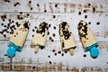 Homemade coffee popsicles on wooden plank.