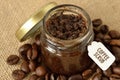 Homemade coffee scrub in a glass jar over jute sack and coffee b