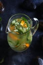 Homemade cold lemonade based on cucumber, mint and orange. Fresh fruit in a misted glass jar. Pieces of ice. Black Royalty Free Stock Photo