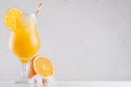 Homemade cold summer fresh oranges lemonade with ice cubes, straw and slice orange on white wooden board. Royalty Free Stock Photo