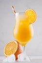 Homemade cold summer fresh oranges lemonade with ice cubes, straw and slice orange on white wooden board, vertical, closeup. Royalty Free Stock Photo