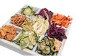 Homemade colorful chips of different fresh vegetables in a white wooden box on a white background. Isolated.