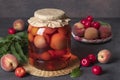 Homemade compote with peaches and cherry plum in glass jar on gray background Royalty Free Stock Photo