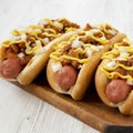 Homemade Coney Island chili dog on a rustic wooden board on a white wooden background, side view. Close-up Royalty Free Stock Photo