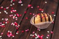 Homemade cookie shaped nuts with cream, chocolate icing on wooden table as a background, red, rose and white sugar sprinkle hearts Royalty Free Stock Photo
