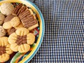 Homemade cookies in a colorful plate on blue white tablecloth