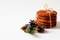 Homemade cookies. Five sweet oatmeal cookies are folded and tied with a linen rope on a white background, decorated with a fir Royalty Free Stock Photo