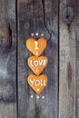 Homemade cookies in the form of heart with letteing I Love You and sweets sugar candy hearts on the rustic wooden background. Vale