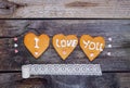 Homemade cookies in the form of heart with letteing I Love You and sweets sugar candy hearts, vintage ribbon on the rustic wooden