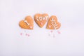 Homemade cookies in the form of heart with letteing I Love You and sweets sugar candy hearts on the white background. Valentine da