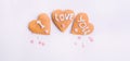 Homemade cookies in the form of heart with letteing I Love You and sweets sugar candy hearts on the white background. Valentine da