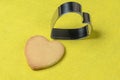 Homemade cookies with a metal baking dish in the shape of a heart on a yellow background Royalty Free Stock Photo