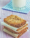 Homemade cookies, muesli bars with glass of milk on a wooden table