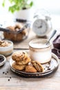 Homemade cookies with nuts and coffee in a ceramic cup on a wooden table. Time to drink some coffee. Alarm clock in the background Royalty Free Stock Photo