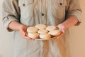 Homemade cookies on a plate held by a girl in a gray shirt on a white background