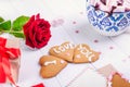 Homemade cookies in shape of heart with I Love you words on the white wooden table with greeting card, flower, gift box and cup of Royalty Free Stock Photo