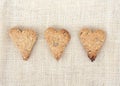 Homemade cookies in the shape of hearts on the burlap. Three heart. top view. Cookies with sunflower seeds. Royalty Free Stock Photo