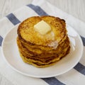 Homemade corn meal Johnny cakes with butter on a white plate, side view. Closeup