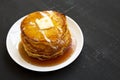 Homemade corn meal Johnny cakes on a white plate on a black background, side view. Copy space