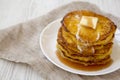 Homemade corn meal Johnny cakes on a white plate on a white wooden table, side view. Copy space