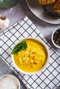 Homemade corn soup with spices and basil in a bowl on the table top and vertical view Royalty Free Stock Photo