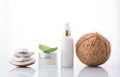 Homemade cosmetic coconut products with coconut on white background. Lotion cream with coconut stack and green leaf.