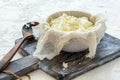 Fresh cottage cheese in a bowl and cheesecloth.