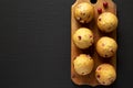 Homemade Cranberry Muffins with Orange Zest on a rustic wooden board on a black background, top view. Space for text Royalty Free Stock Photo