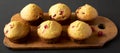 Homemade Cranberry Muffins with Orange Zest on a rustic wooden board on a black surface, side view Royalty Free Stock Photo
