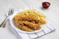 Homemade Crispy Chicken Tenders and French Fries on a white plate, side view Royalty Free Stock Photo