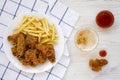 Homemade Crispy Chicken wings and French Fries with sour-sweet sauce and glass of cold beer on a white wooden background, top view Royalty Free Stock Photo