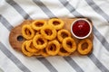 Homemade Crispy Deep-Fried Onion Rings with Ketchup on a rustic wooden board, top view. Flat lay Royalty Free Stock Photo