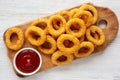 Homemade Crispy Deep-Fried Onion Rings with Ketchup on a rustic wooden board, top view. Flat lay Royalty Free Stock Photo