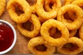 Homemade Crispy Deep-Fried Onion Rings with Ketchup on a rustic wooden board, top view. Flat lay. Close-up Royalty Free Stock Photo