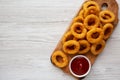 Homemade Crispy Deep-Fried Onion Rings with Ketchup on a rustic wooden board, top view. Flat lay. Copy space Royalty Free Stock Photo