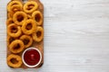 Homemade Crispy Deep-Fried Onion Rings with Ketchup on a rustic wooden board, top view. Flat lay. Space for text Royalty Free Stock Photo